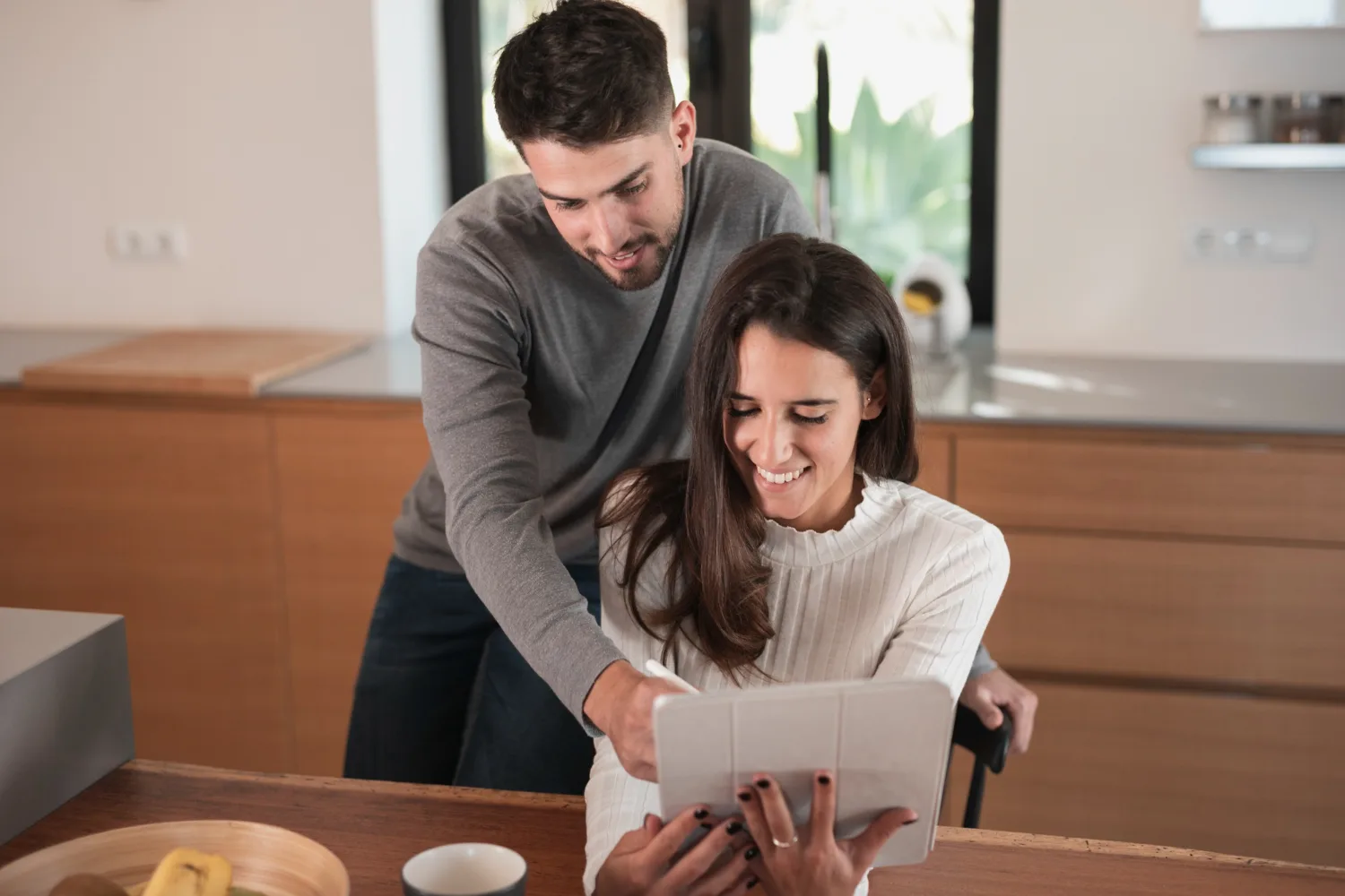 Couple looking at house listings on a tablet, showing AI in real estate recommendations