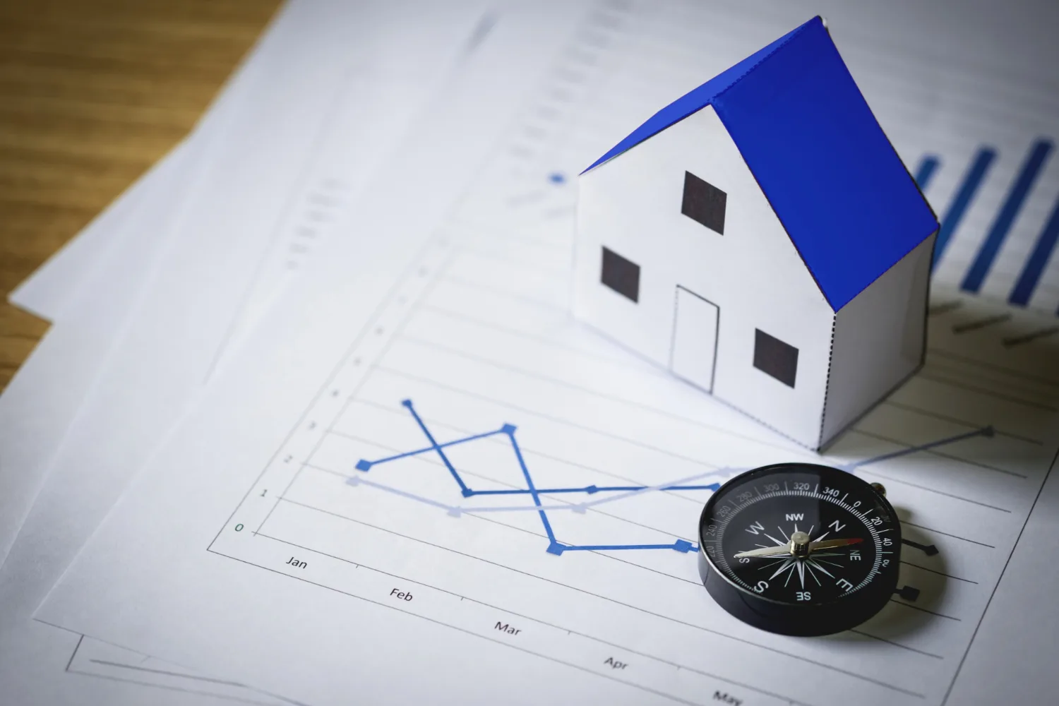 Real estate bubble trend chart with a model house and compass