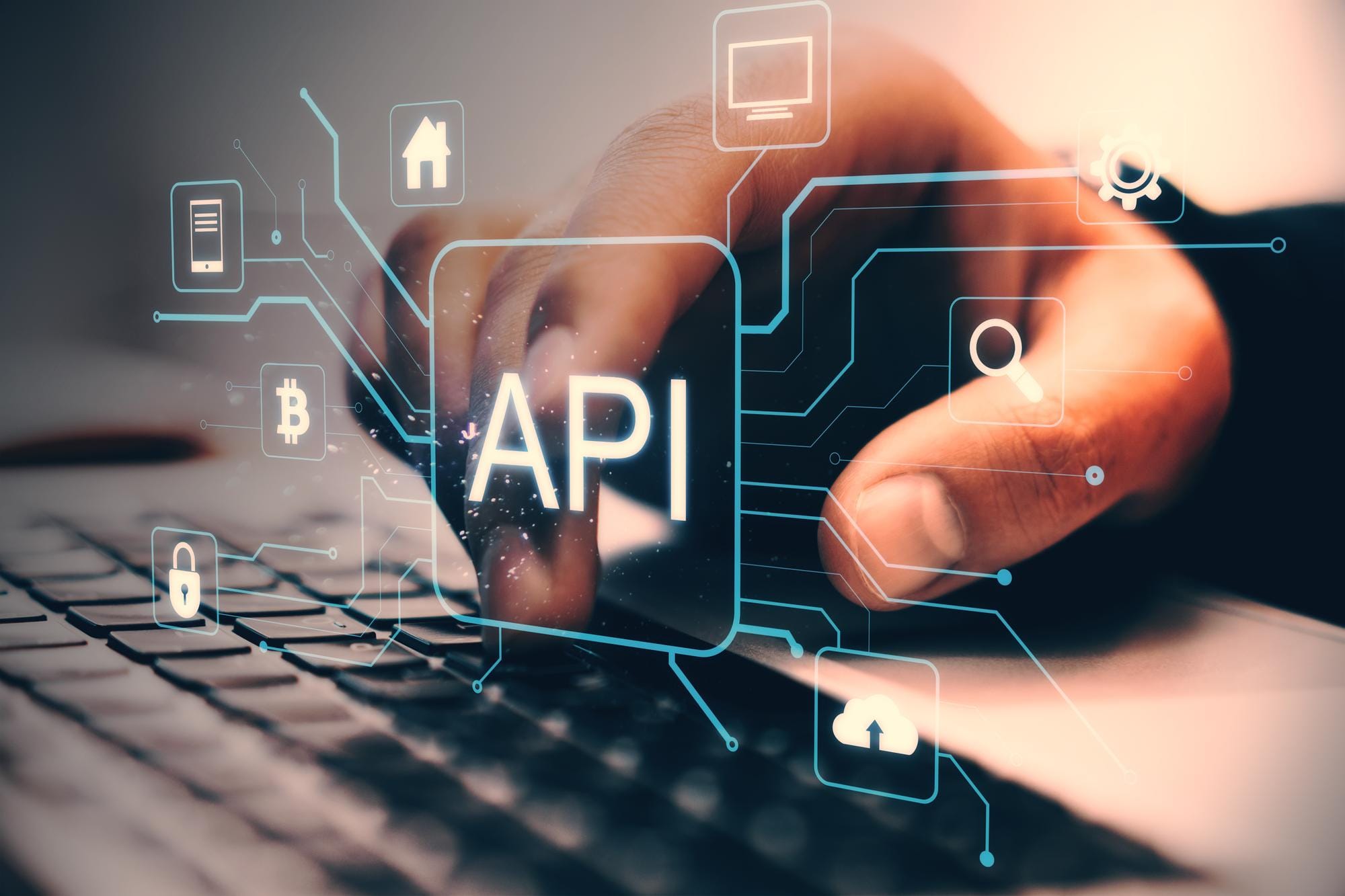 A hand types on a laptop keyboard, with a glowing "API" label surrounded by digital icons representing technology concepts like cybersecurity, cloud storage, cryptocurrency, and data search.