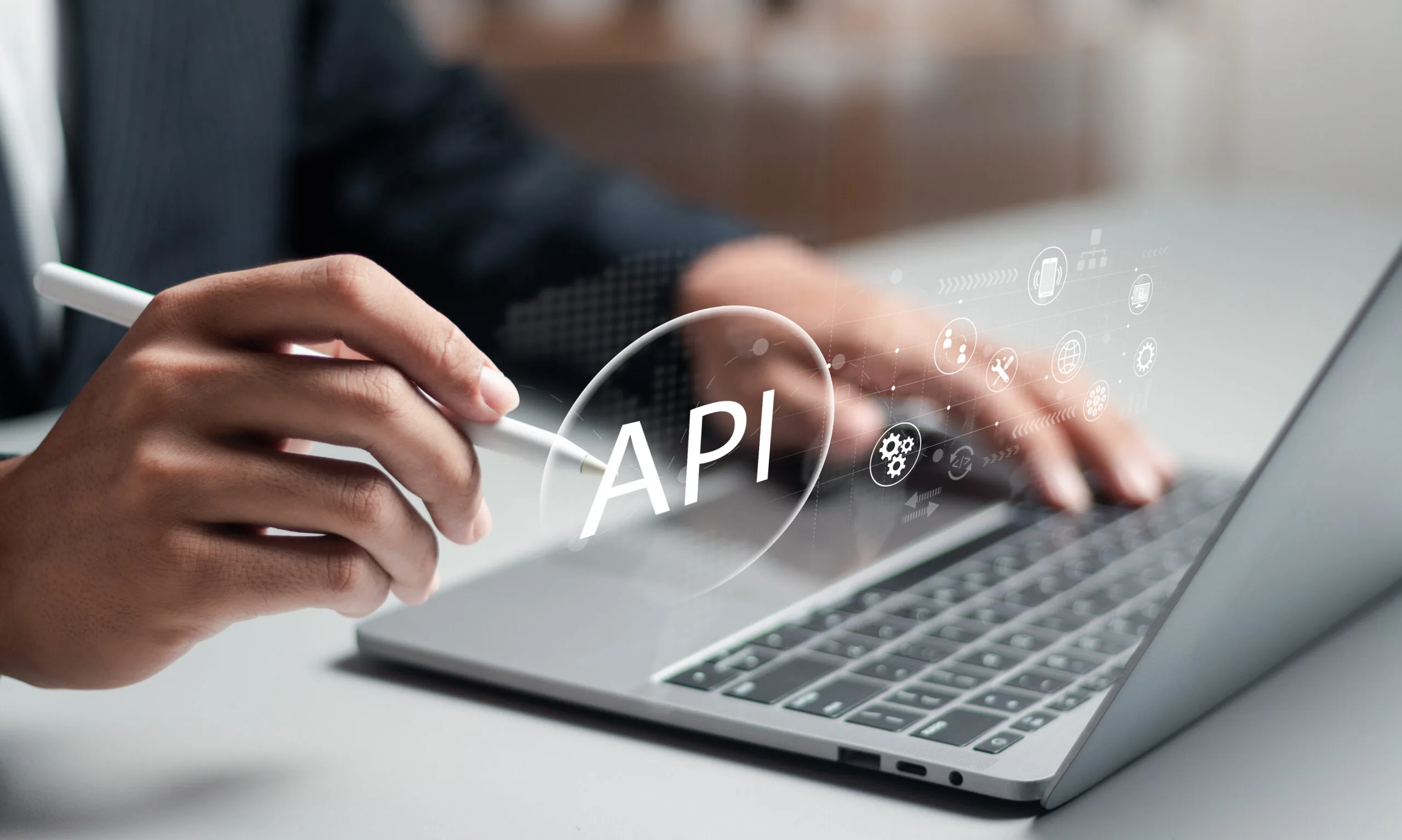 Integrating Real Estate APIs with AI illustrated by developer working on laptop with API technology overlay and connectivity icons