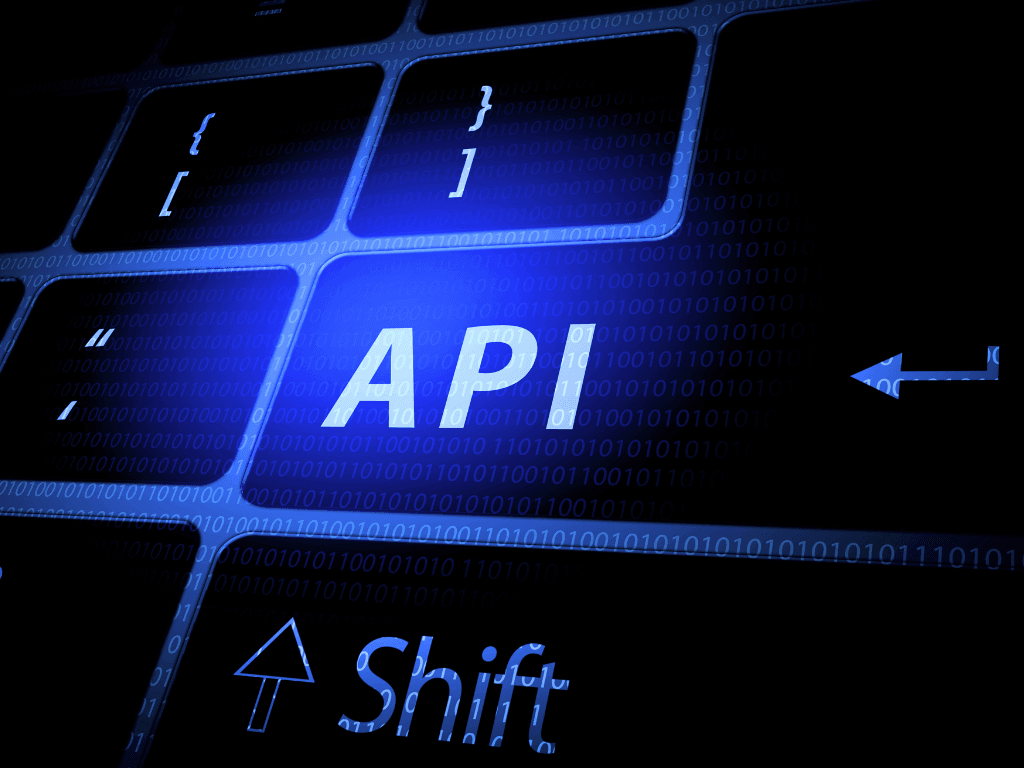 Illuminated computer keyboard with API text and binary code overlay representing real estate API programming and software development