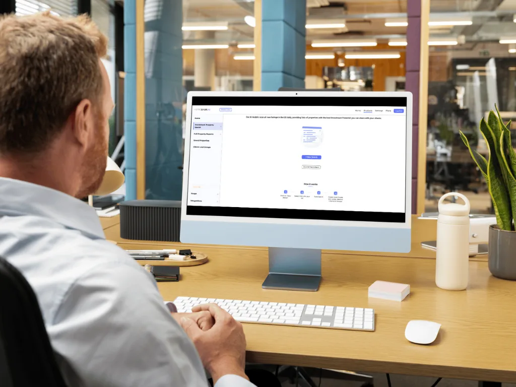 Investor at desk using Homesage.ai software interface for a digital property search on a desktop monitor.