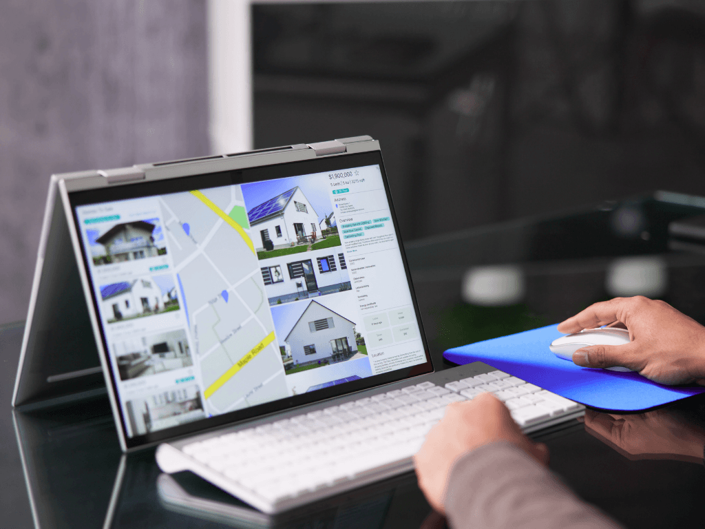 Real estate investor using a modern laptop to analyze property listings and digital maps with AI-powered real estate software
