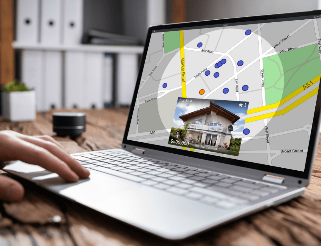 Laptop screen displaying interactive property map with listings and location pins for investment property research