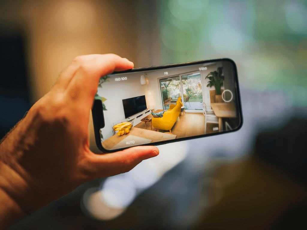 Real estate agent using smartphone to capture property interior for AI-powered virtual staging and immersive marketing