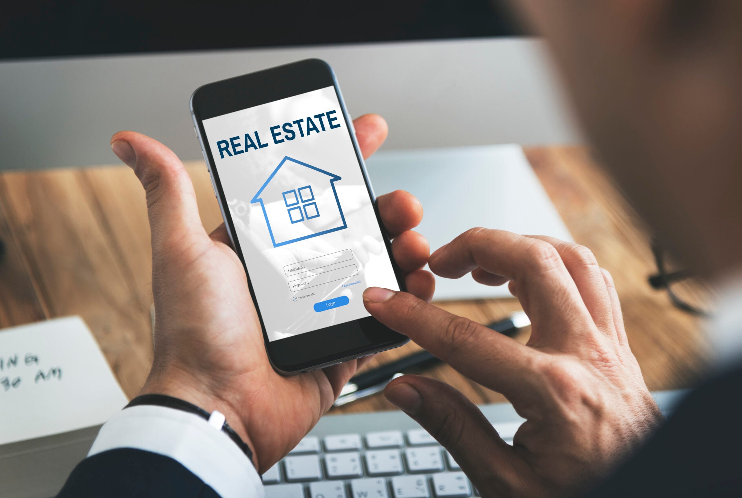 Real estate professional using a property app on a smartphone to access property data for PropTech platform development