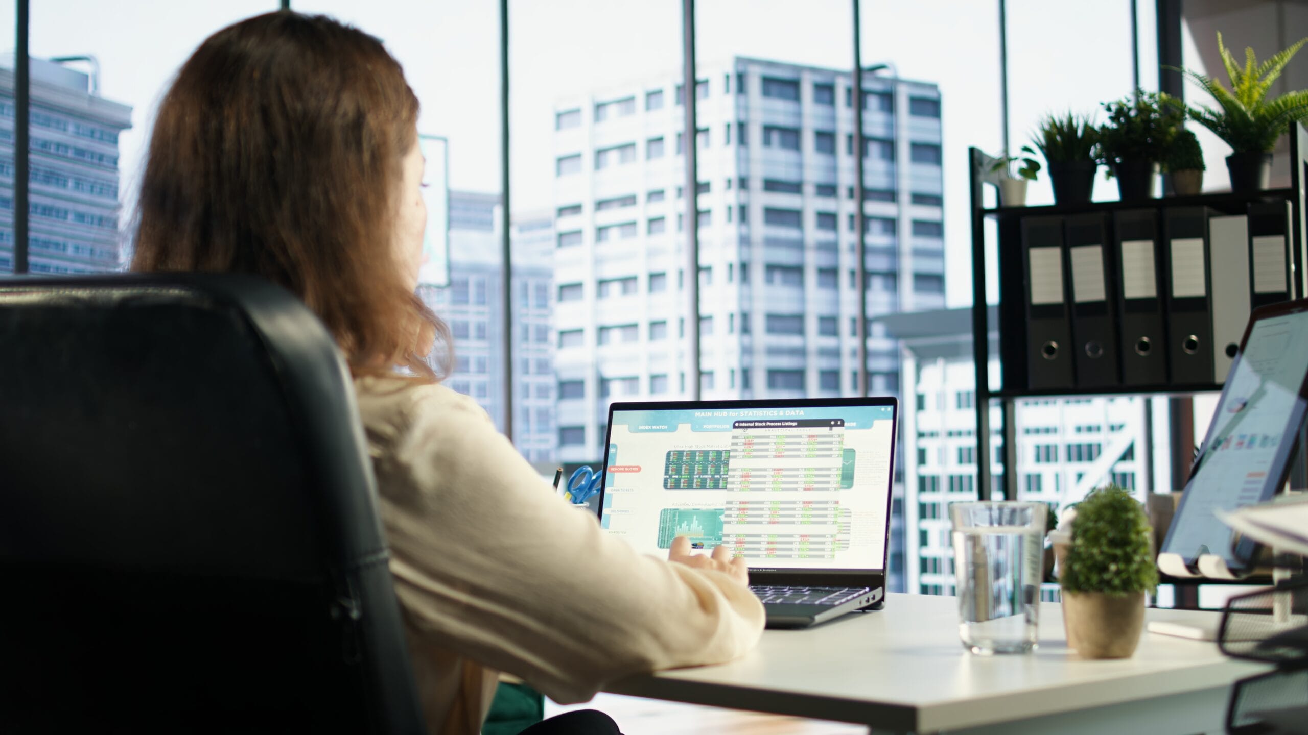 real estate data stack — developer reviewing property data dashboards on laptop in modern high-rise office