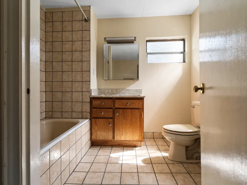 Bathroom with dated tile, tub and vanity